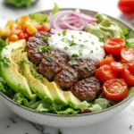 Fresh and colorful burger bowl with beef patty and vegetables.