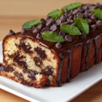 Close-up of a chocolate chip cake recipe garnished with mint and chocolate chips.