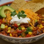 Taco soup frios garnished with sour cream, cheese, and avocado.