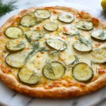 Homemade pickle pie pizza with golden crust and fresh dill.