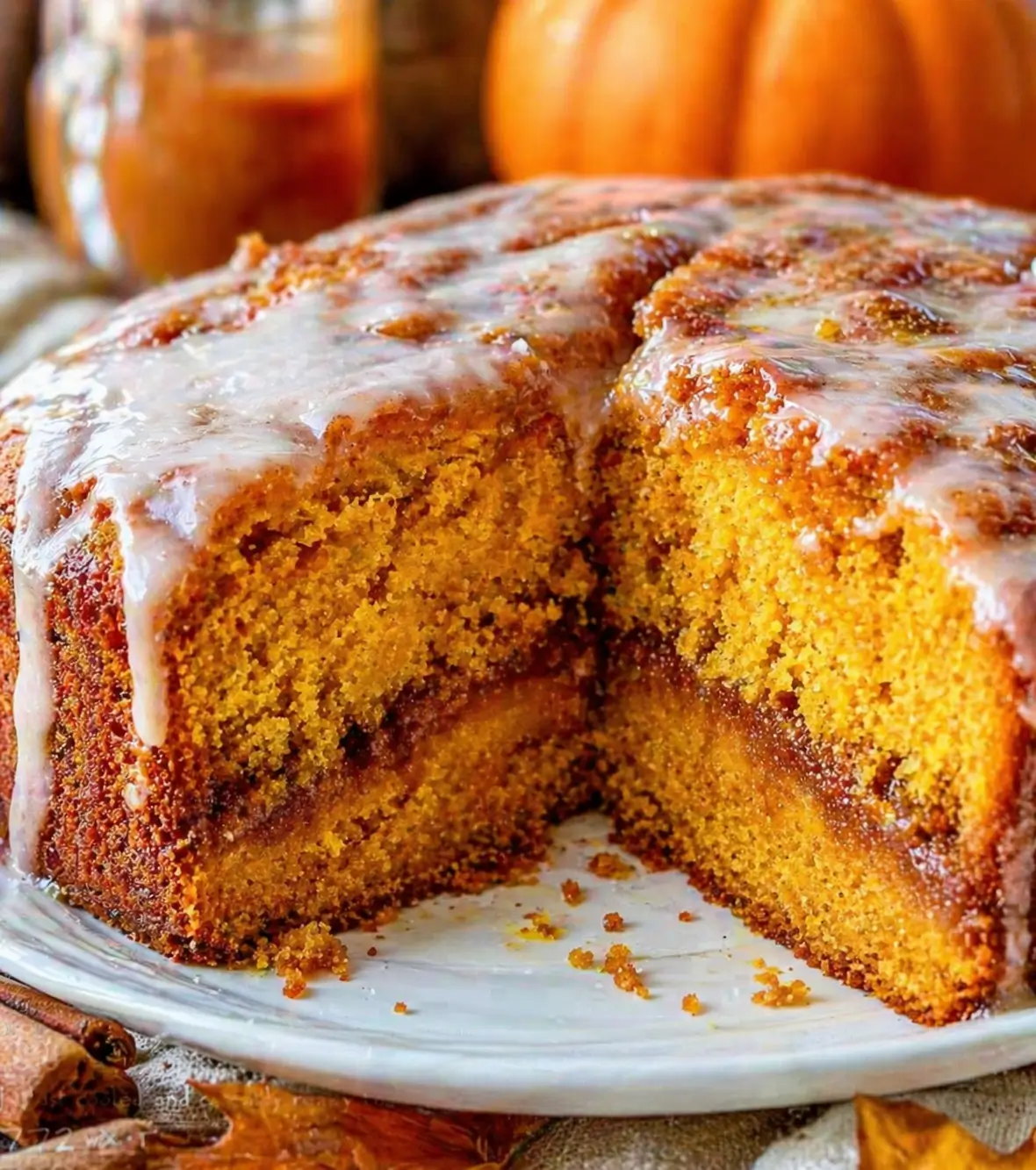 Close-up of pumpkin honey bun cake with cinnamon swirl and white glaze